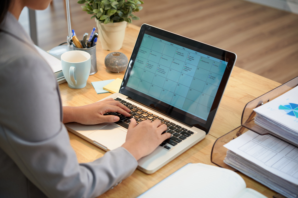 A person typing on a laptop at the table