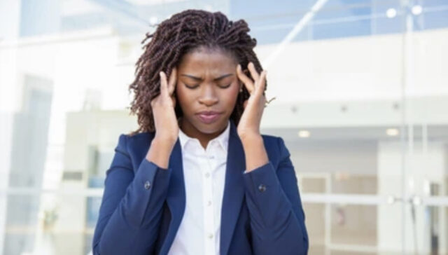 A woman holding her hands to her head